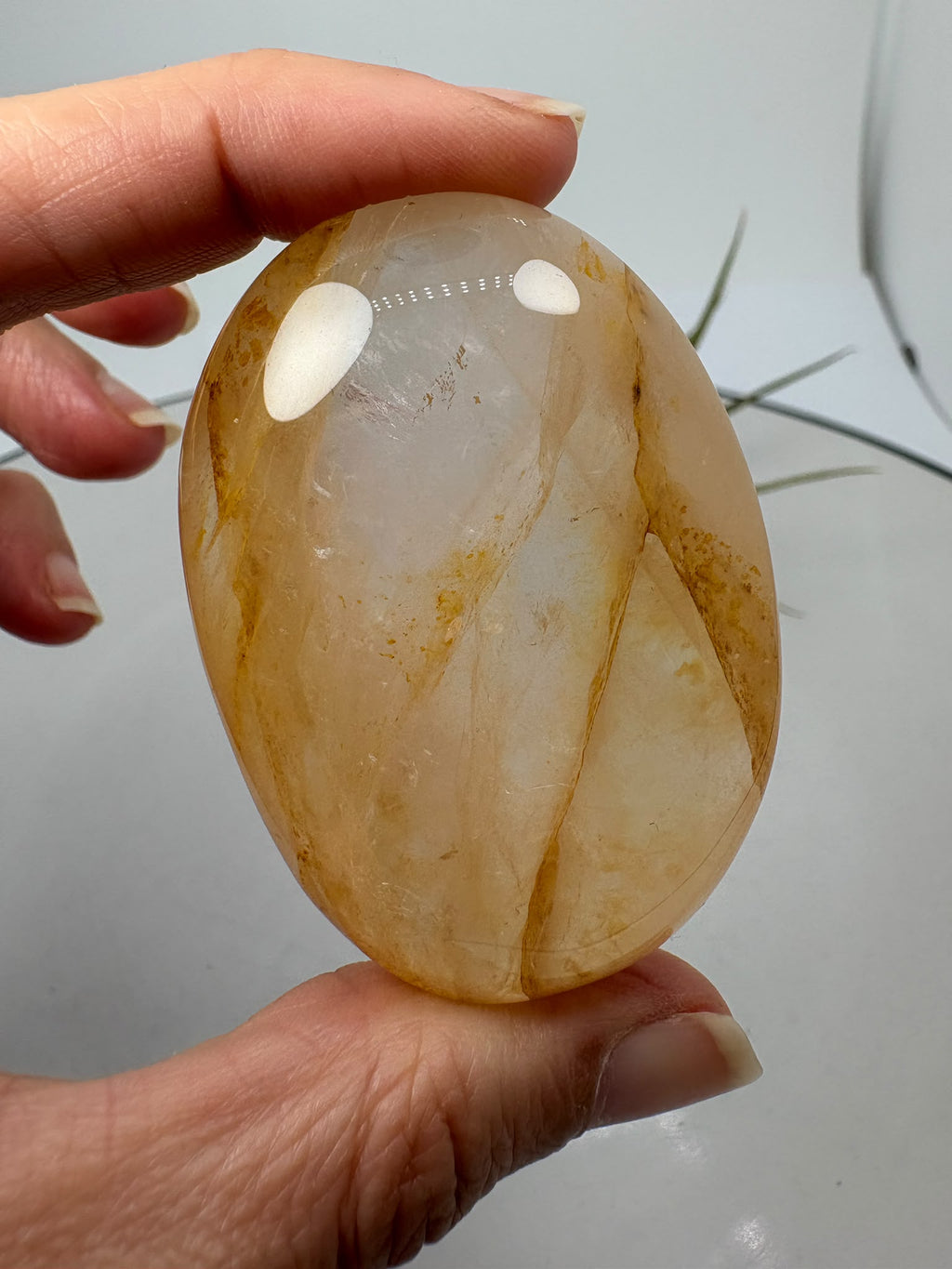 Palmstone de cuarzo hematoide de gran calidad y transparencia. Su interior presenta preciosas inclusiones en tonos anaranjados, rojizos y dorados, acompañadas de dibujos oscuros que forman un paisaje único dentro del cuarzo.