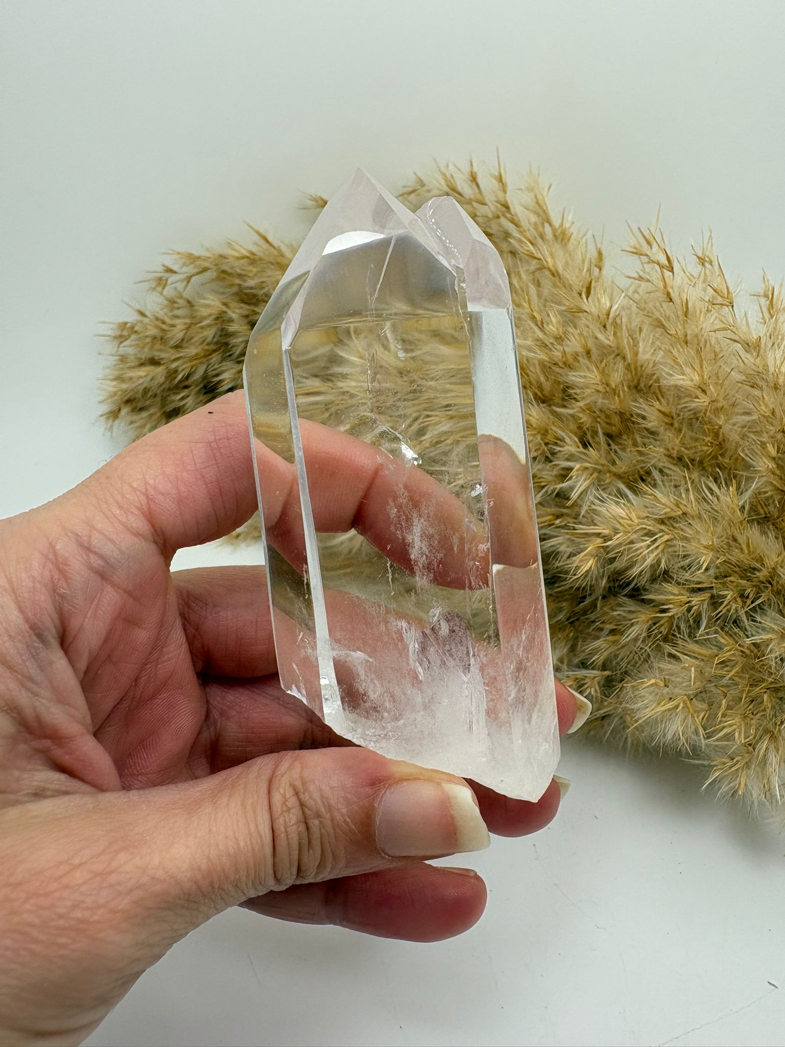 Cuarzo cristal natural pulido con zonas en bruto y arcoíris interno