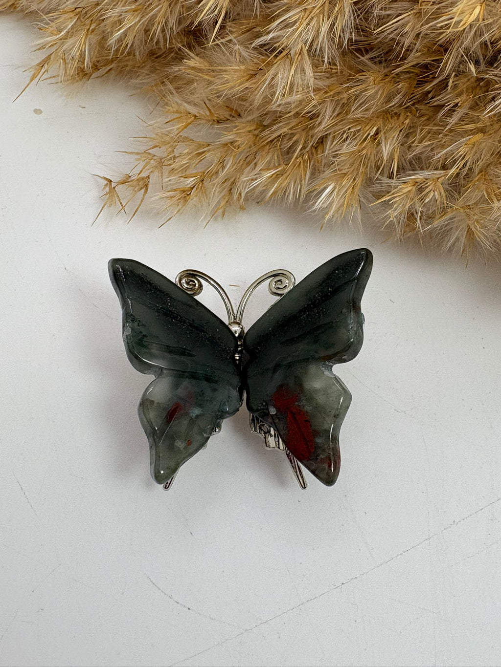 Mariposa de heliotropo pulido, piedra natural con vetas rojizas características. Figura única perfecta para decoración o colección.