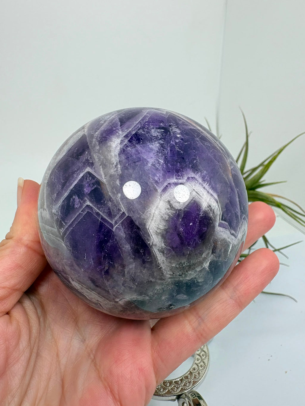Esfera de amatista africana natural de 6,9 cm. Pieza única de intensos tonos violetas, ideal para colección, decoración, meditación y armonización de espacios. La base no está incluida.