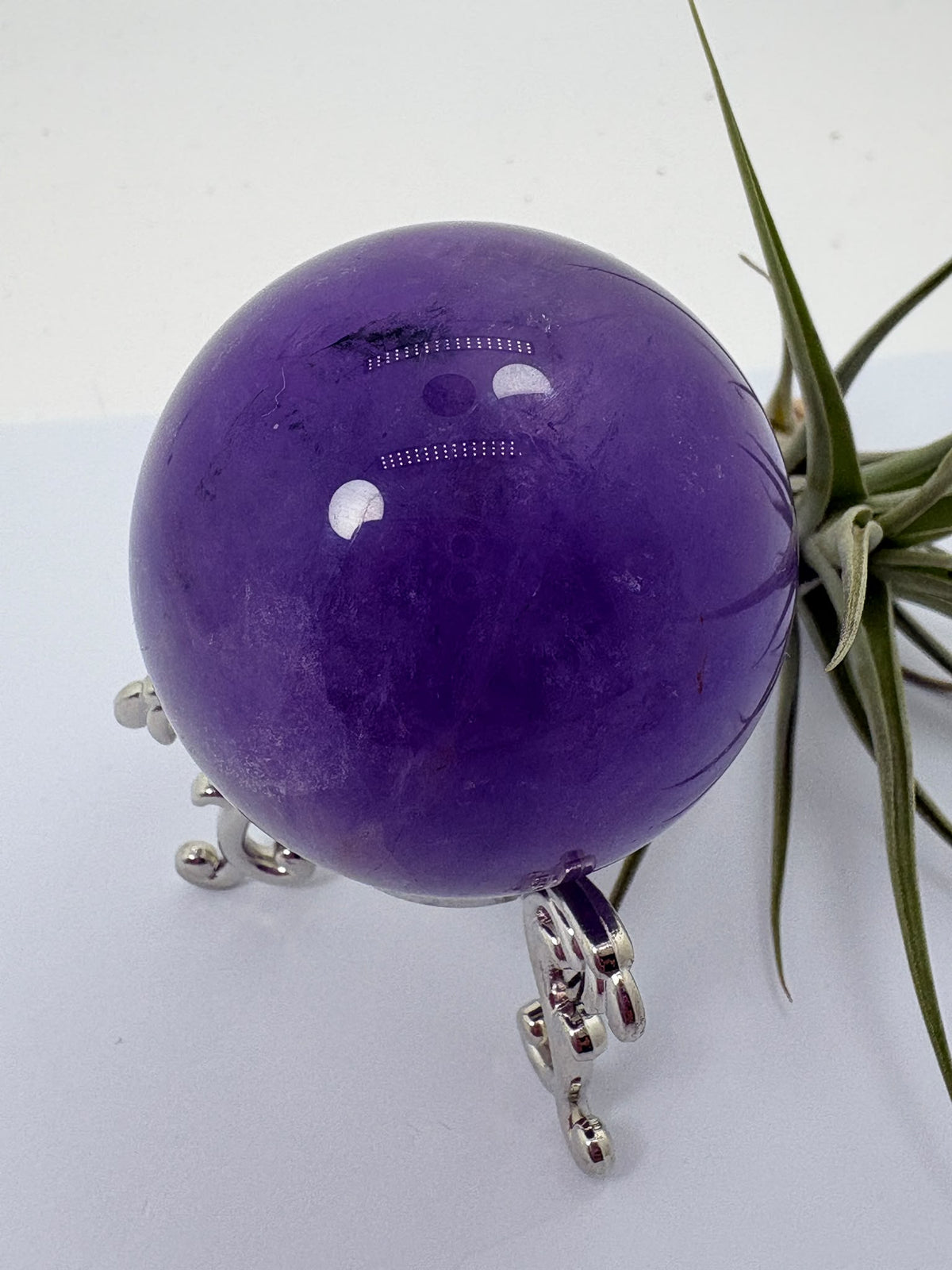Esfera de amatista lila con zona ahumada y acabado pulido. Una pieza única para decorar o acompañar tu meditación en La Hada de las Piedras.