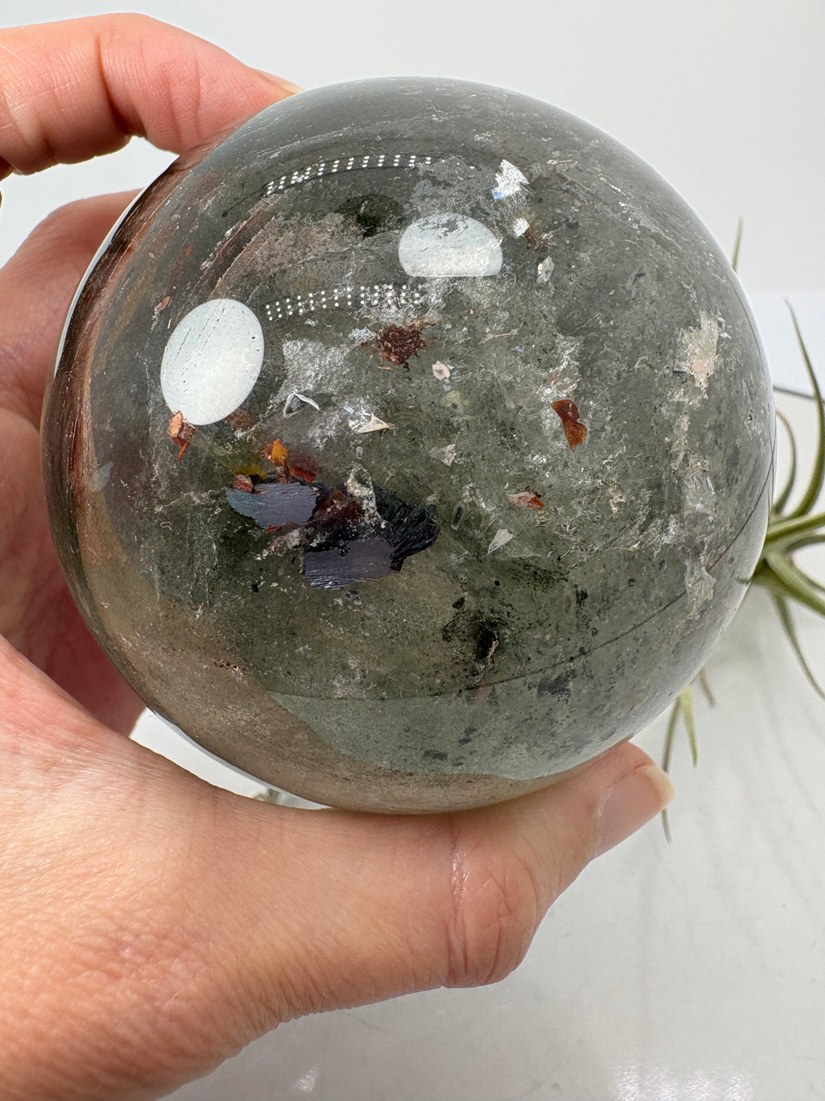 Impresionante esfera de cuarzo chamánico de gran tamaño, una pieza única llena de carácter y belleza natural.

Su interior presenta inclusiones, velos y fracturas naturales que crean espectaculares reflejos arcoíris al recibir la luz.