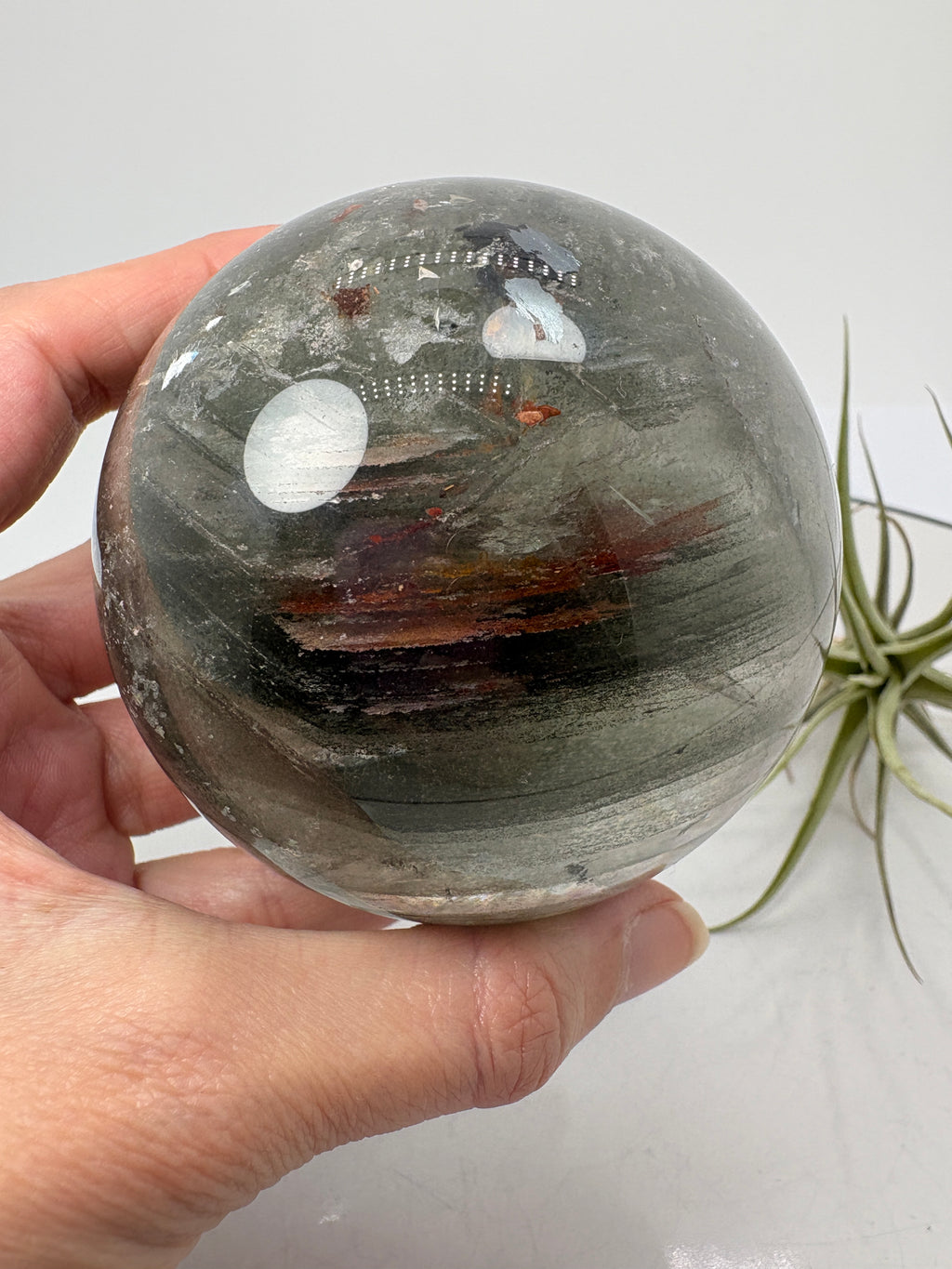 Impresionante esfera de cuarzo chamánico de gran tamaño, una pieza única llena de carácter y belleza natural.

Su interior presenta inclusiones, velos y fracturas naturales que crean espectaculares reflejos arcoíris al recibir la luz.