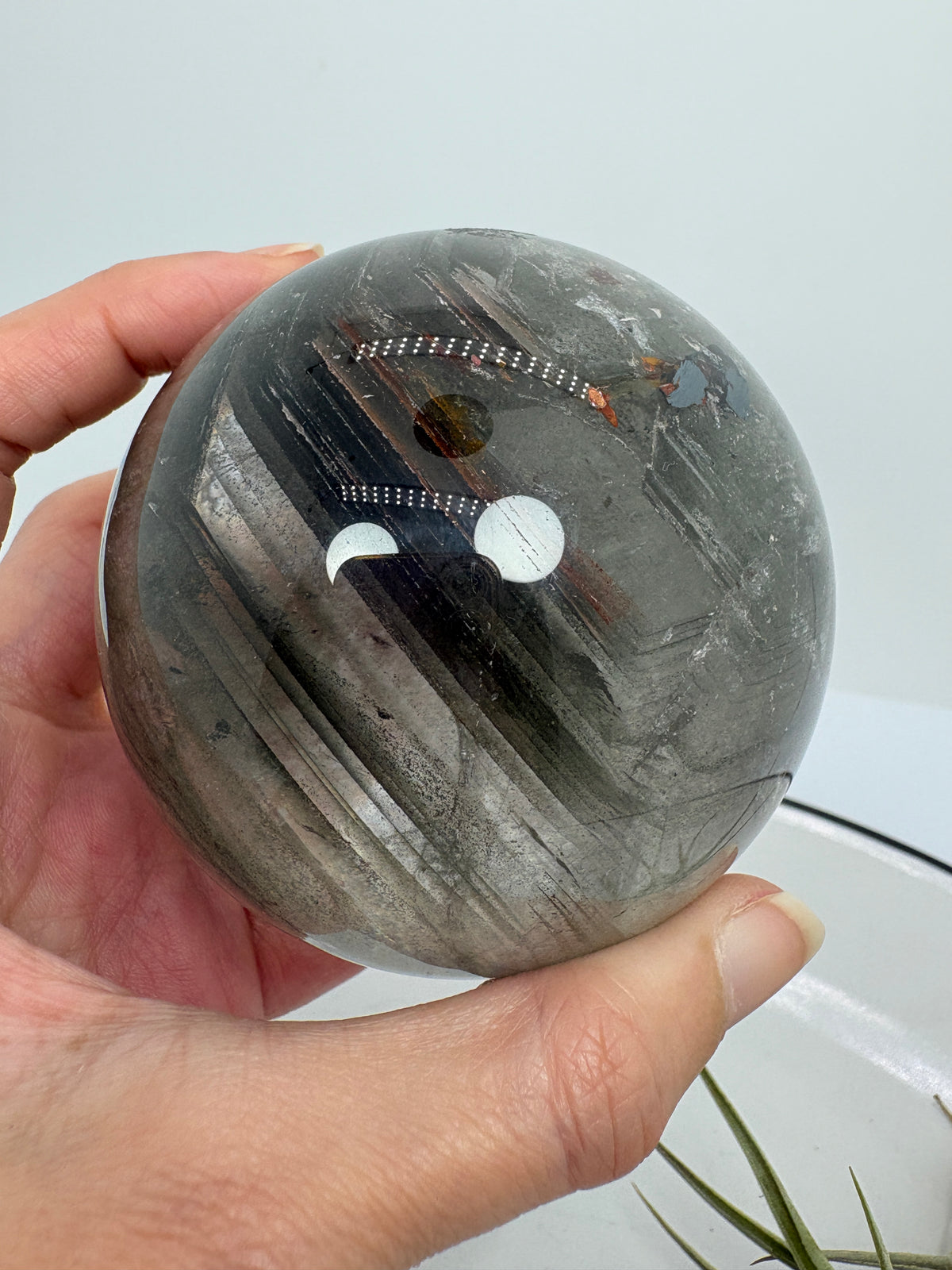 Impresionante esfera de cuarzo chamánico de gran tamaño, una pieza única llena de carácter y belleza natural.

Su interior presenta inclusiones, velos y fracturas naturales que crean espectaculares reflejos arcoíris al recibir la luz.