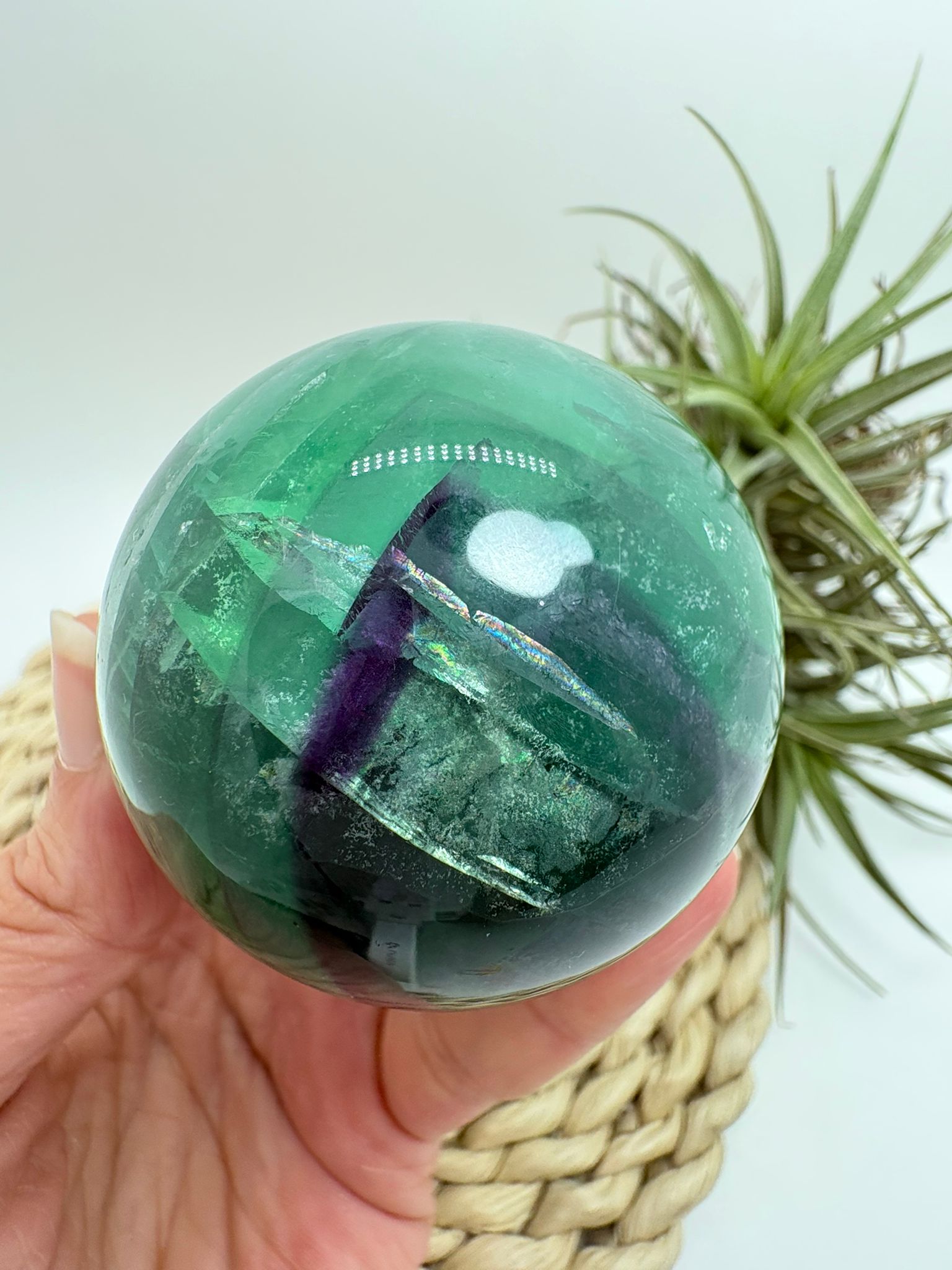 Esfera de fluorita arcoíris natural con tonos verdes y violetas. Ideal para aportar equilibrio, claridad mental y armonía energética.