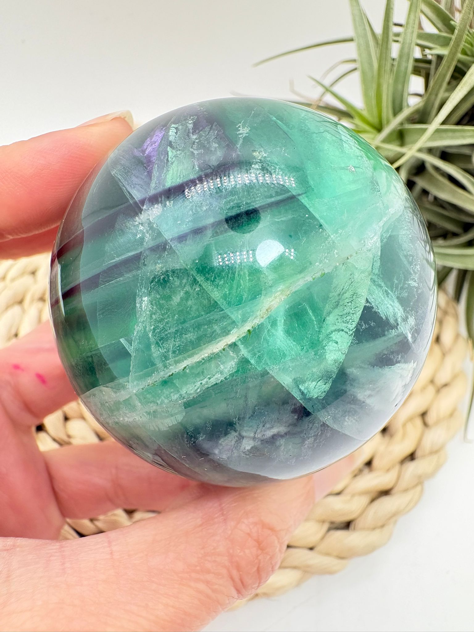 Esfera de fluorita arcoíris natural con tonos verdes y violetas. Ideal para aportar equilibrio, claridad mental y armonía energética.