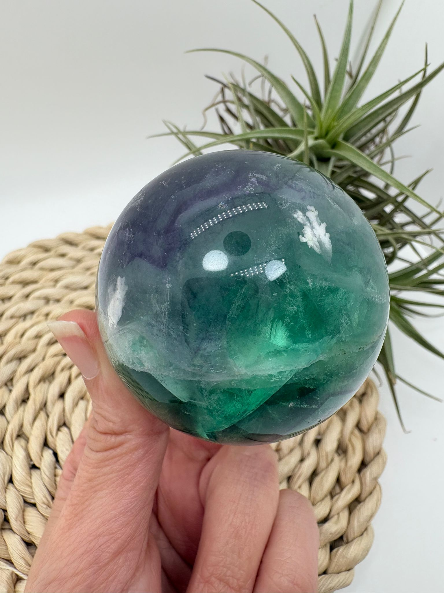 Esfera de fluorita arcoíris natural con tonos verdes y violetas. Ideal para aportar equilibrio, claridad mental y armonía energética.