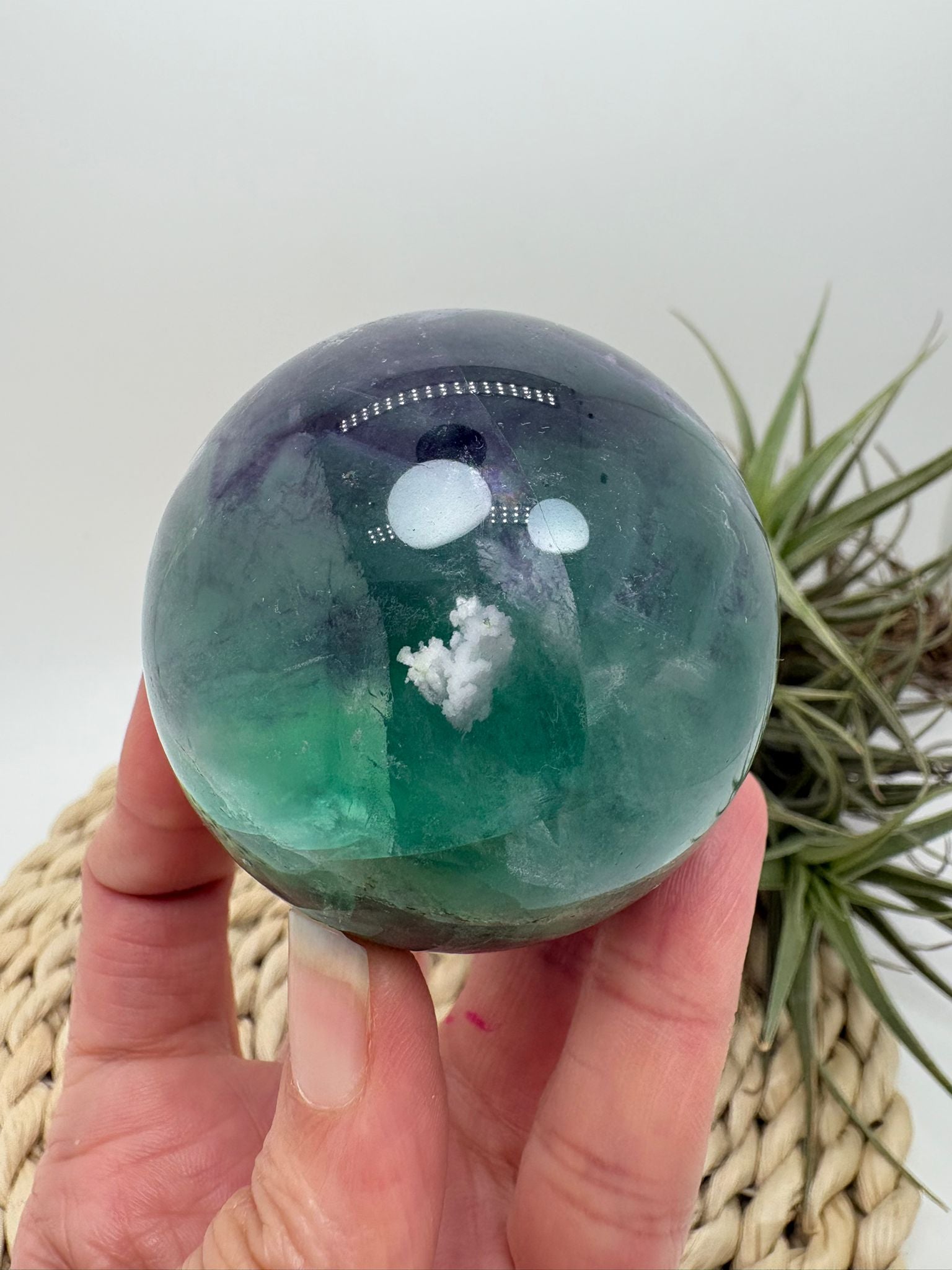 Esfera de fluorita arcoíris natural con tonos verdes y violetas. Ideal para aportar equilibrio, claridad mental y armonía energética.