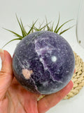 Esfera de lepidolita natural en tonos lilas, asociada con la calma, el equilibrio emocional y la relajación. Pieza única con acabado pulido.