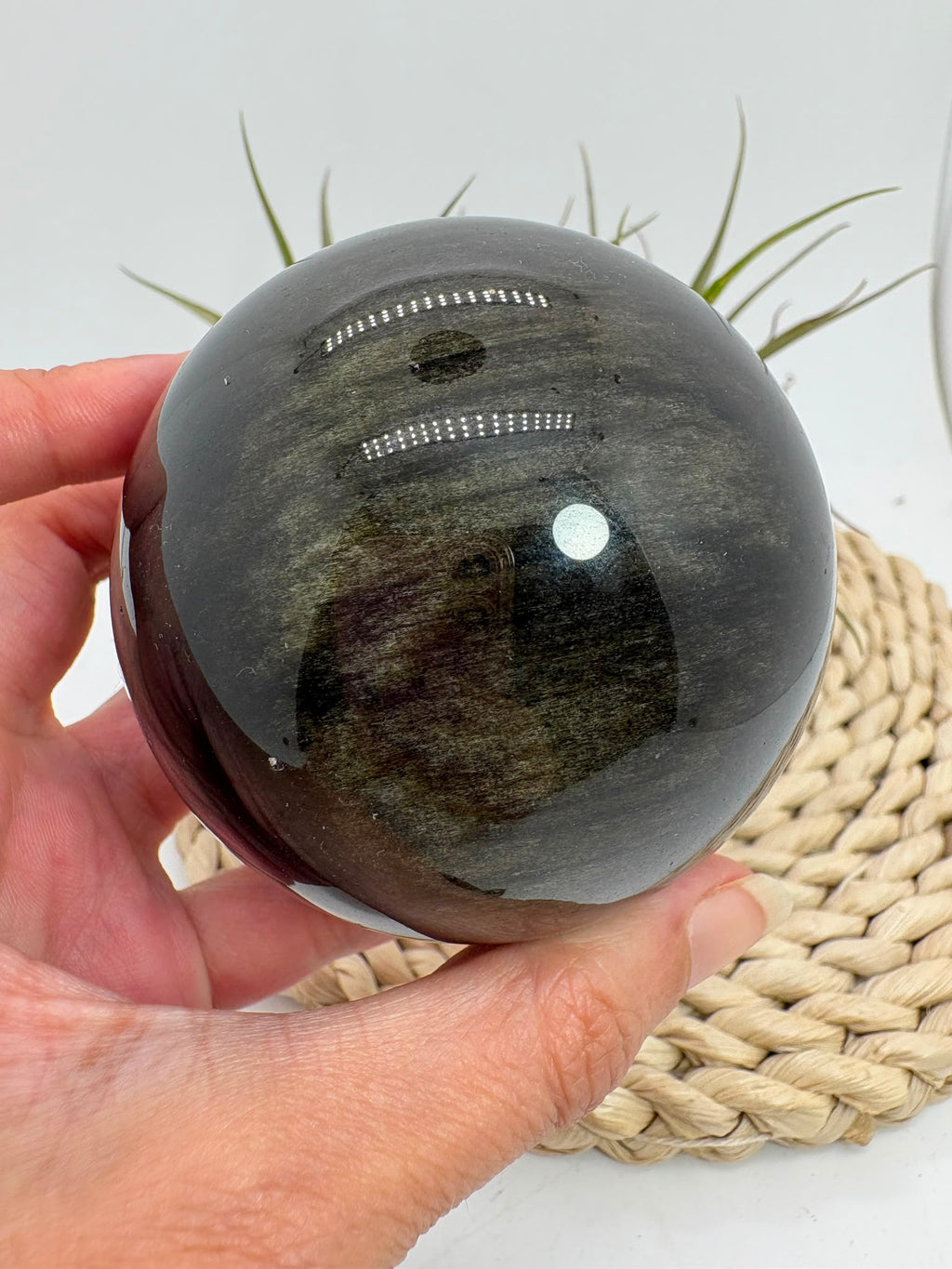 Esfera de obsidiana dorada procedente de México, de gran tamaño y con un intenso acabado pulido. Su superficie oscura revela preciosos reflejos dorados al recibir la luz, creando un efecto brillante y profundo característico de esta variedad de obsidiana.