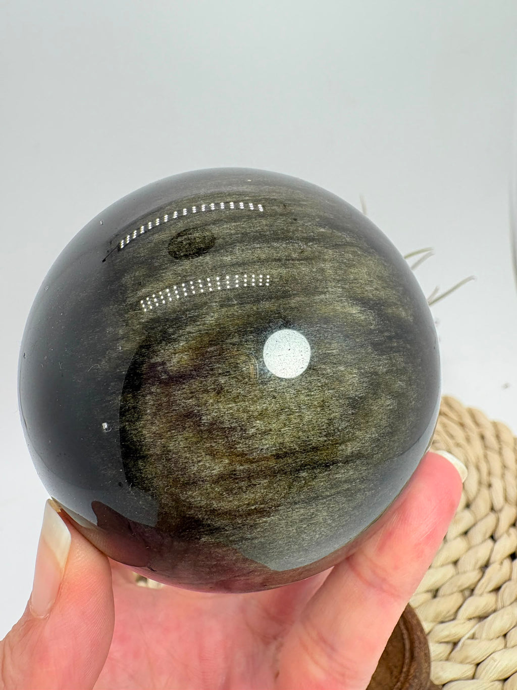 Esfera de obsidiana dorada procedente de México, de gran tamaño y con un intenso acabado pulido. Su superficie oscura revela preciosos reflejos dorados al recibir la luz, creando un efecto brillante y profundo característico de esta variedad de obsidiana.