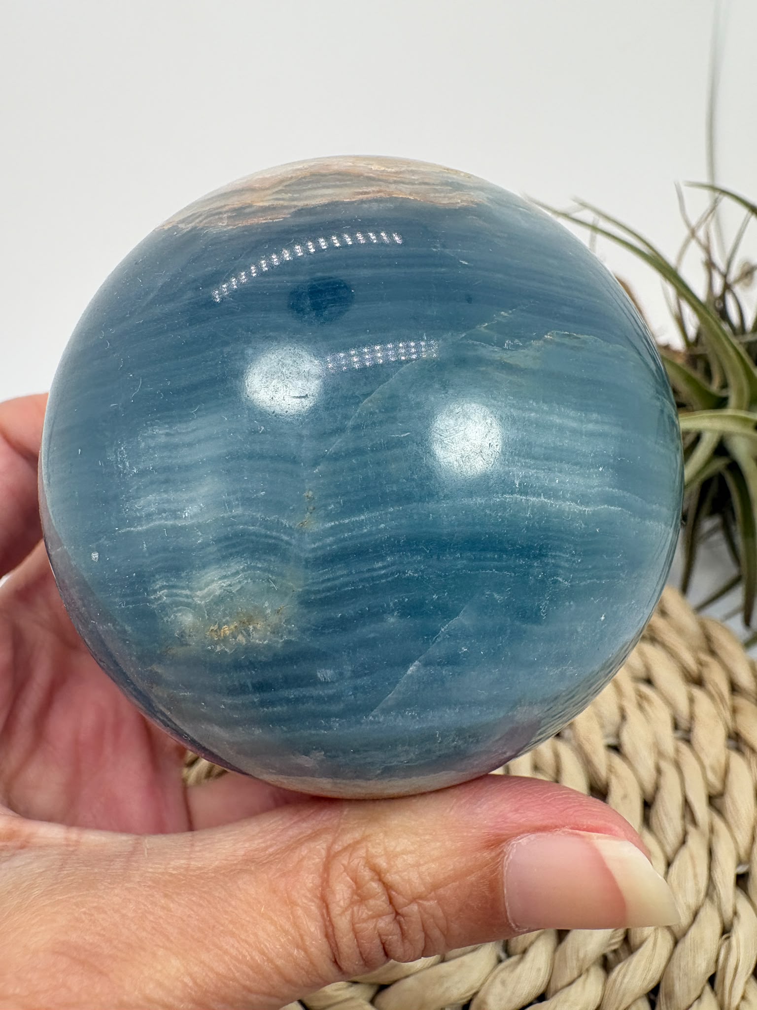 Esfera de ónix azul natural con preciosas bandas y tonalidades azules. Pieza única de acabado pulido, asociada con la calma y la serenidad.