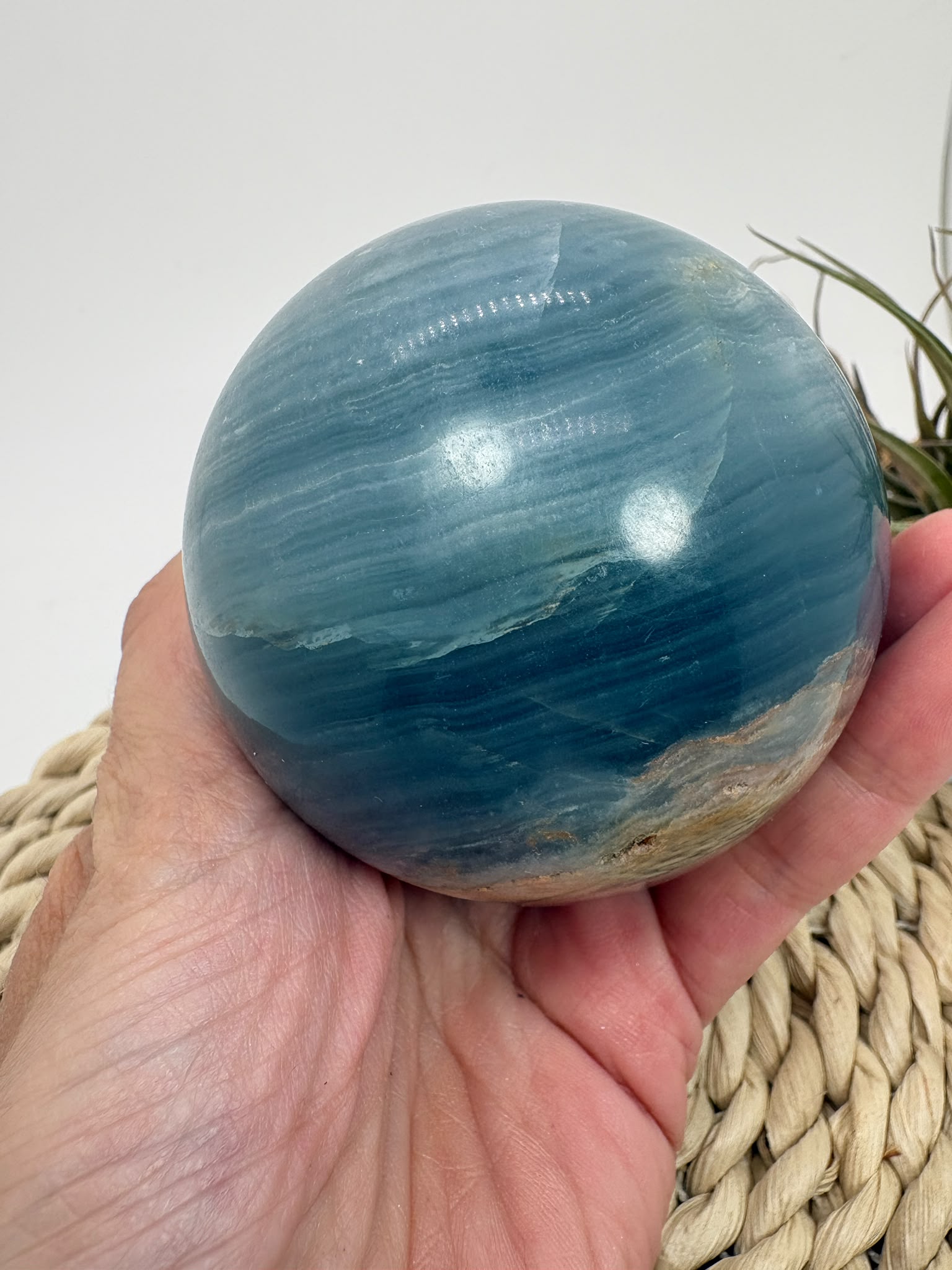 Esfera de ónix azul natural con preciosas bandas y tonalidades azules. Pieza única de acabado pulido, asociada con la calma y la serenidad.