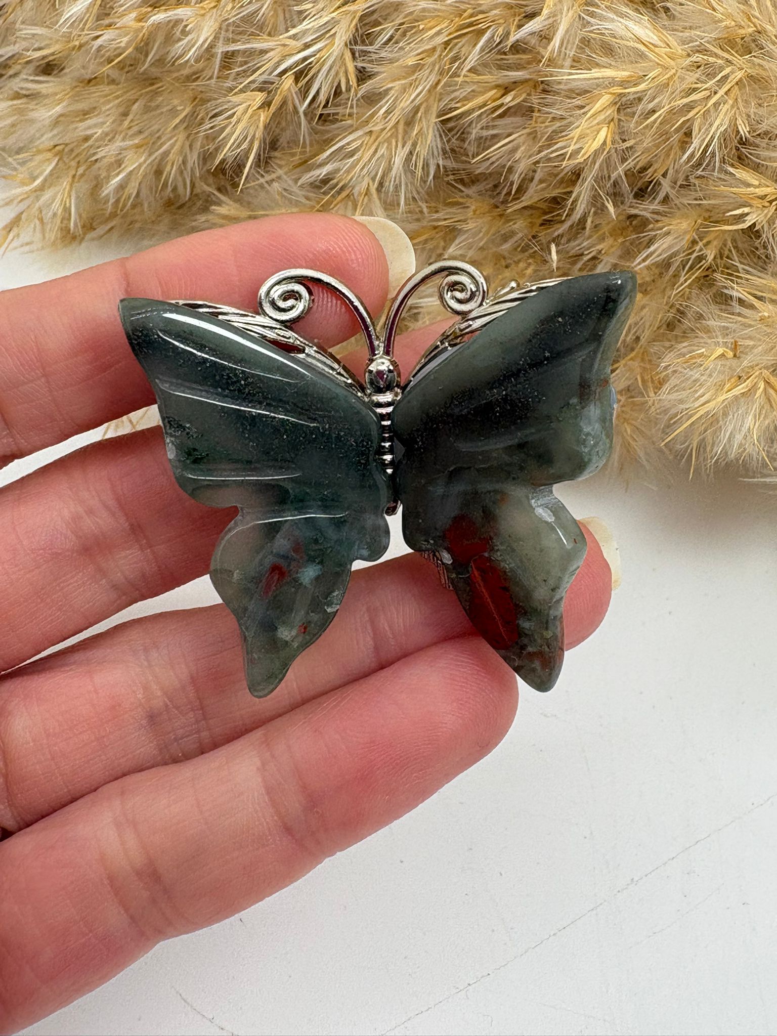 Mariposa de heliotropo pulido, piedra natural con vetas rojizas características. Figura única perfecta para decoración o colección.