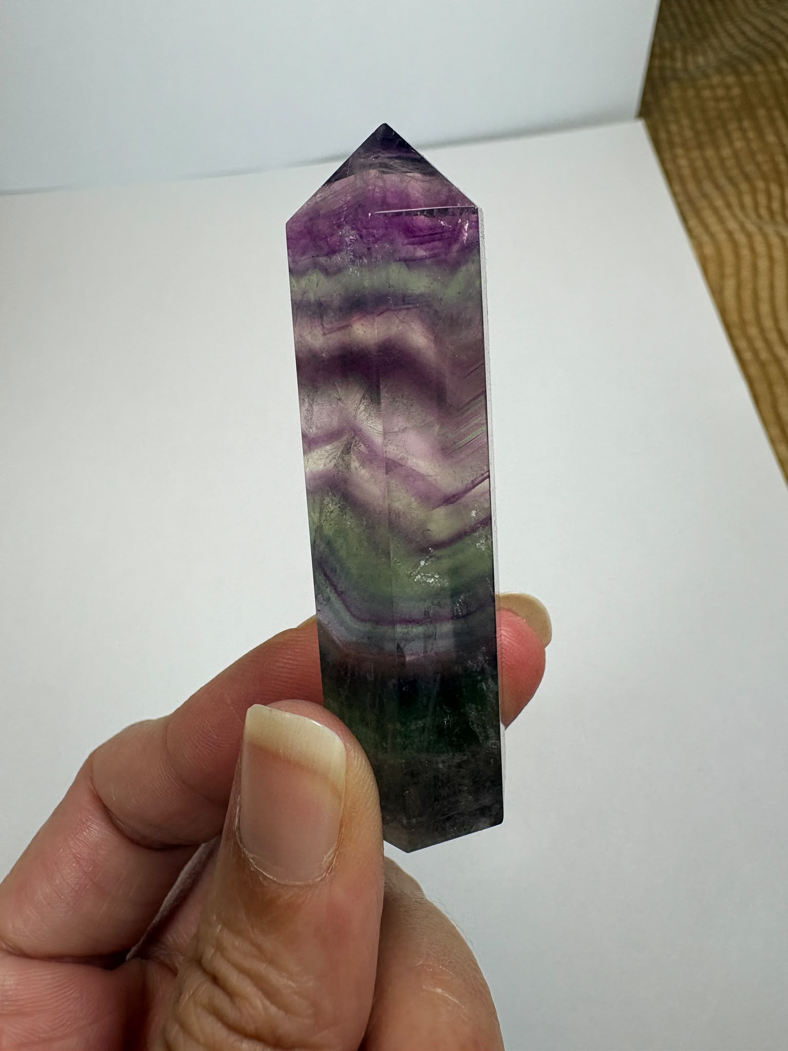 Punta de fluorita arcoíris natural pulida de 6 × 1,5 cm. Pieza única con hermosas bandas de color, ideal para colección, decoración o meditación