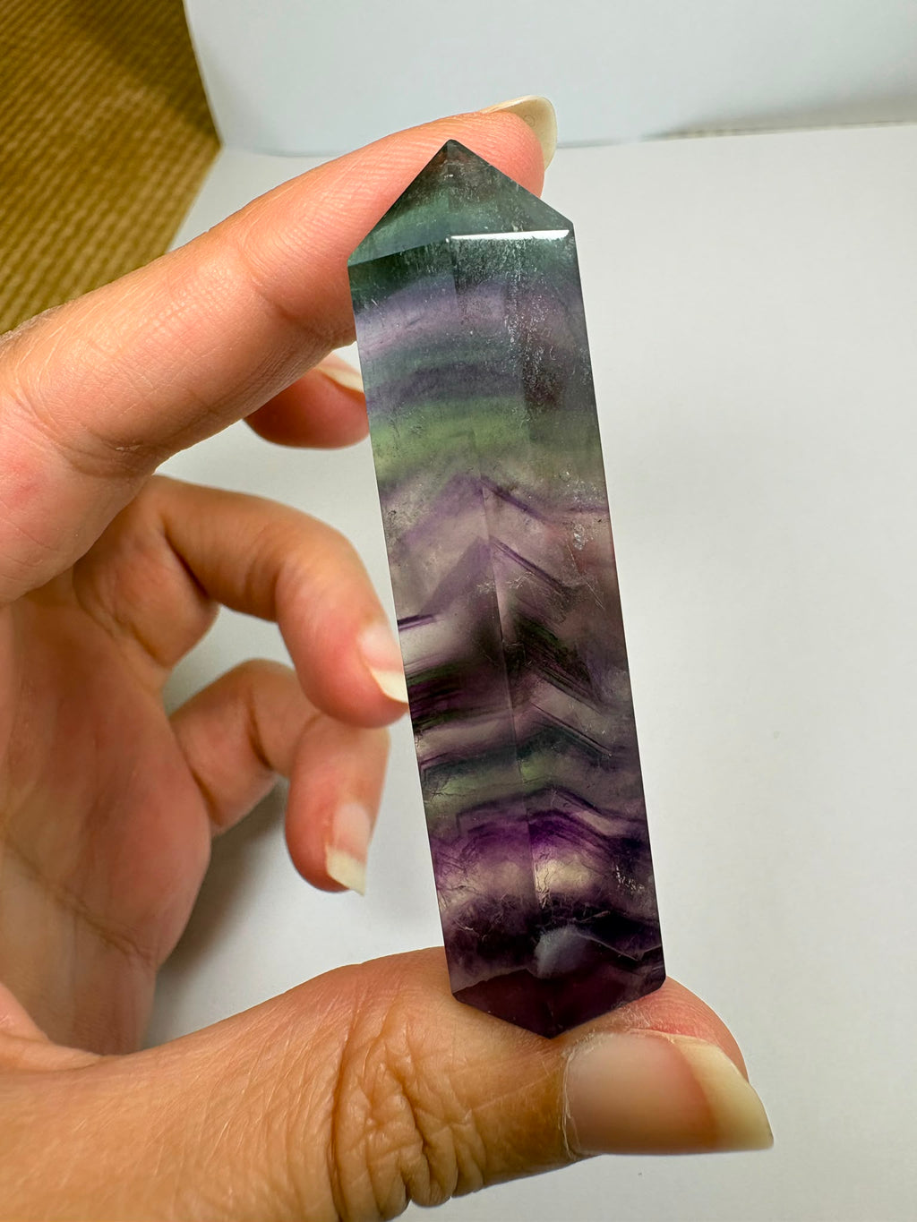 Punta de fluorita arcoíris natural pulida de 6 × 1,5 cm. Pieza única con hermosas bandas de color, ideal para colección, decoración o meditación