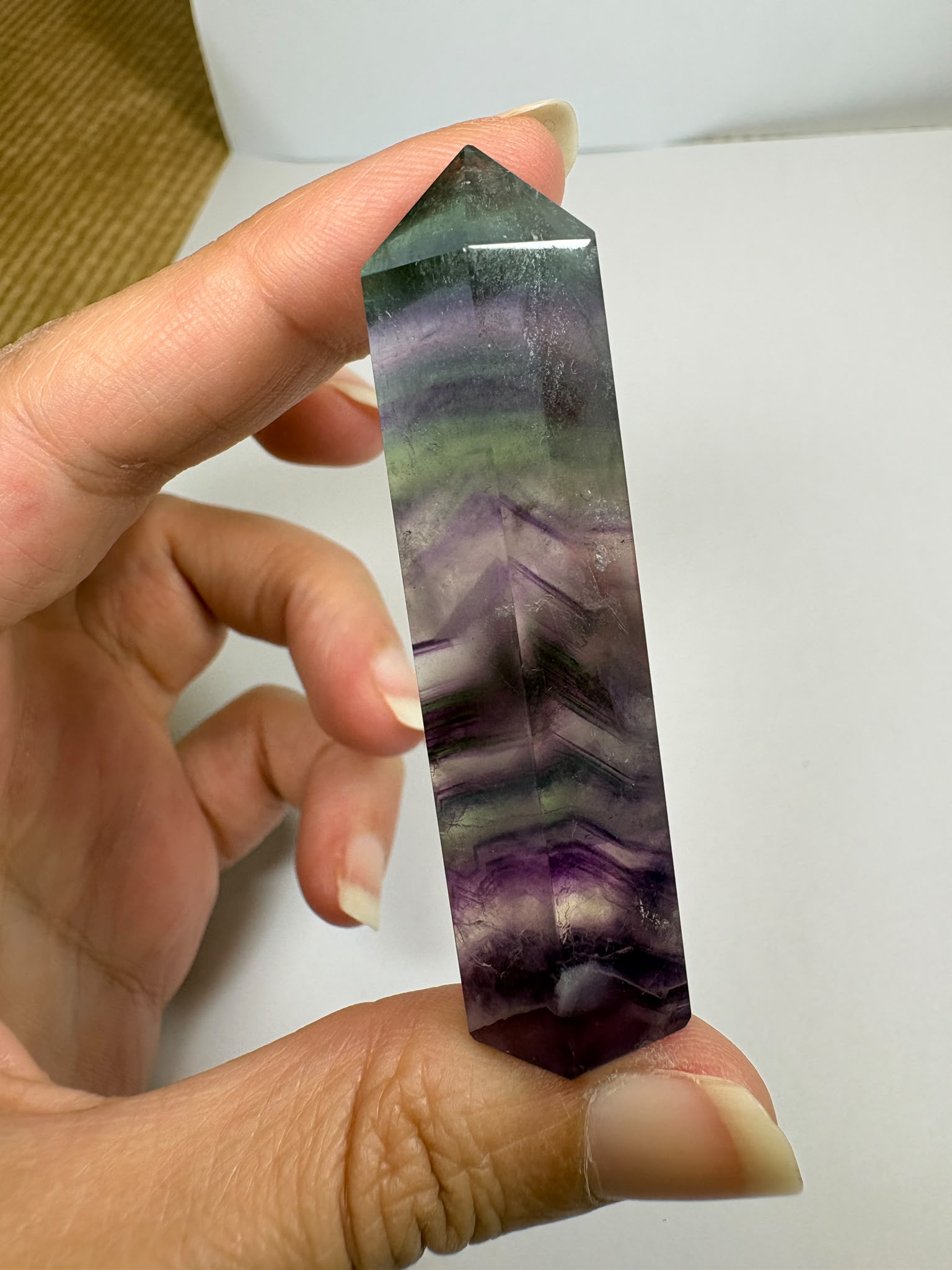 Punta de fluorita arcoíris natural pulida de 6 × 1,5 cm. Pieza única con hermosas bandas de color, ideal para colección, decoración o meditación