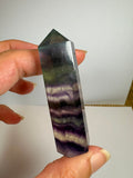 Punta de fluorita arcoíris natural pulida de 6 × 1,5 cm. Pieza única con hermosas bandas de color, ideal para colección, decoración o meditación