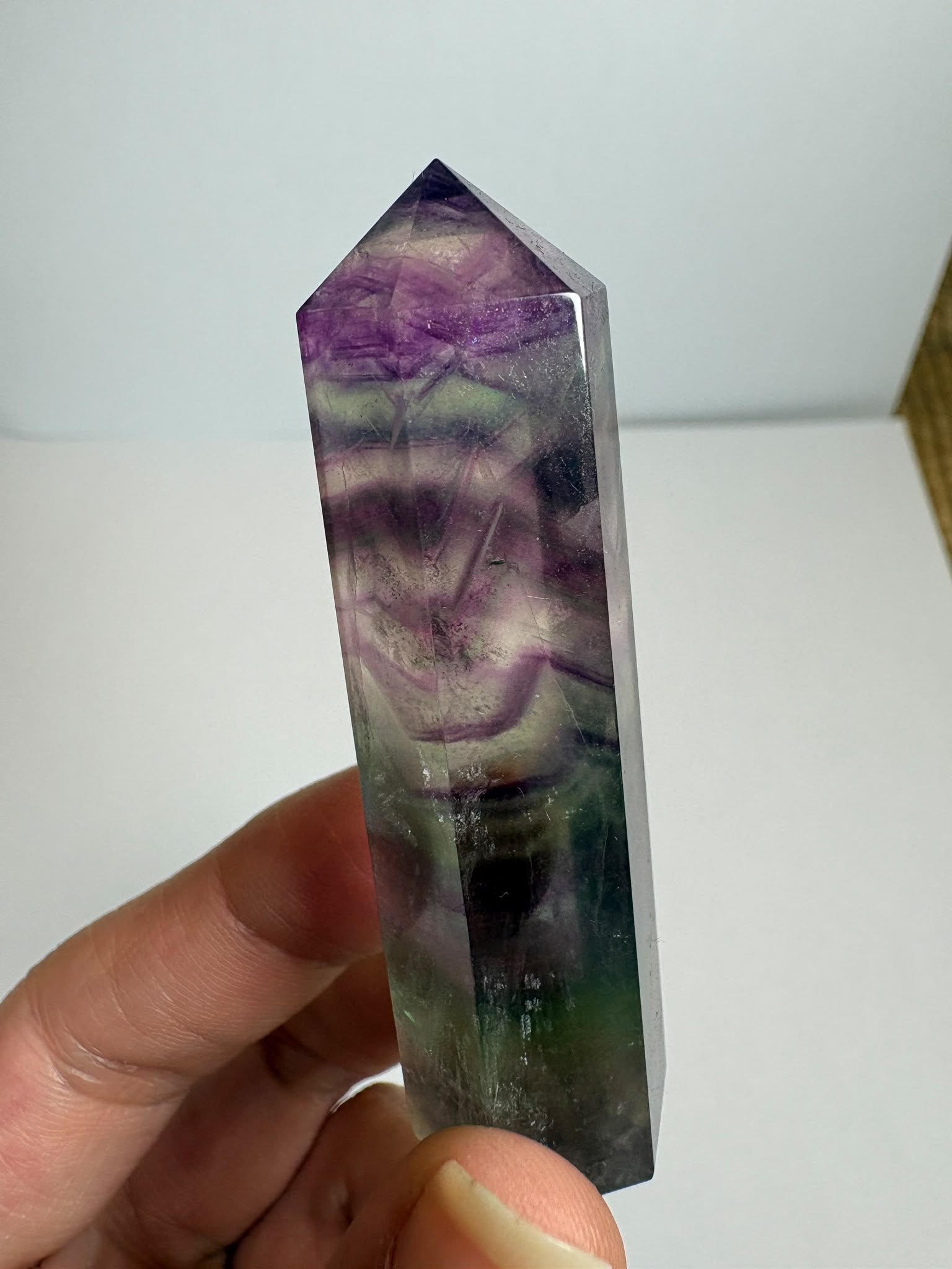 Punta de fluorita arcoíris natural pulida de 6 × 1,5 cm. Pieza única con hermosas bandas de color, ideal para colección, decoración o meditación