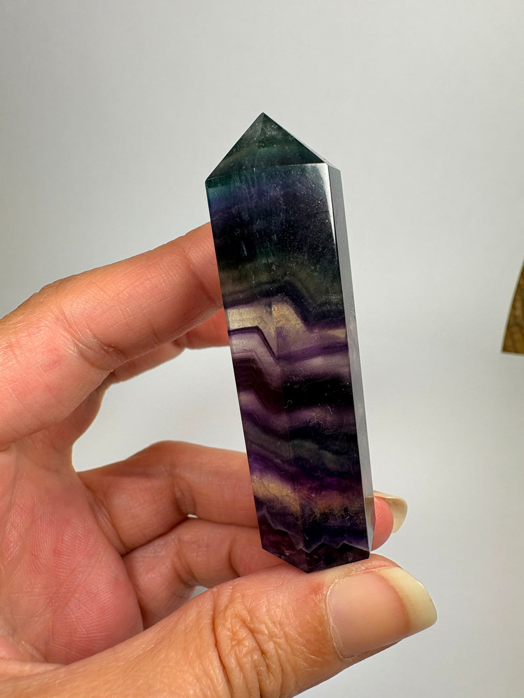 Punta de fluorita arcoíris natural pulida de 6 × 1,5 cm. Pieza única con hermosas bandas de color, ideal para colección, decoración o meditación