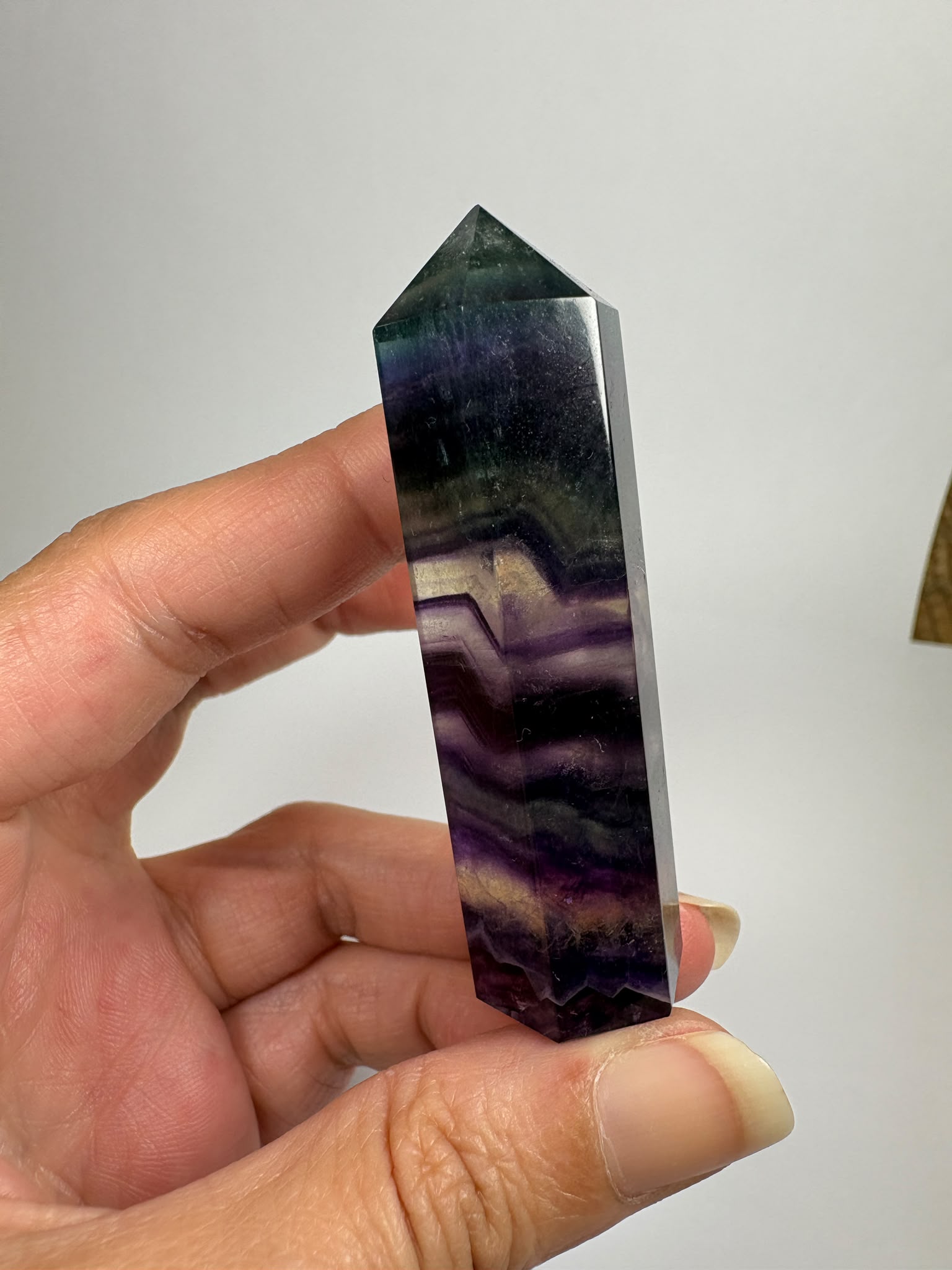 Punta de fluorita arcoíris natural pulida de 6 × 1,5 cm. Pieza única con hermosas bandas de color, ideal para colección, decoración o meditación