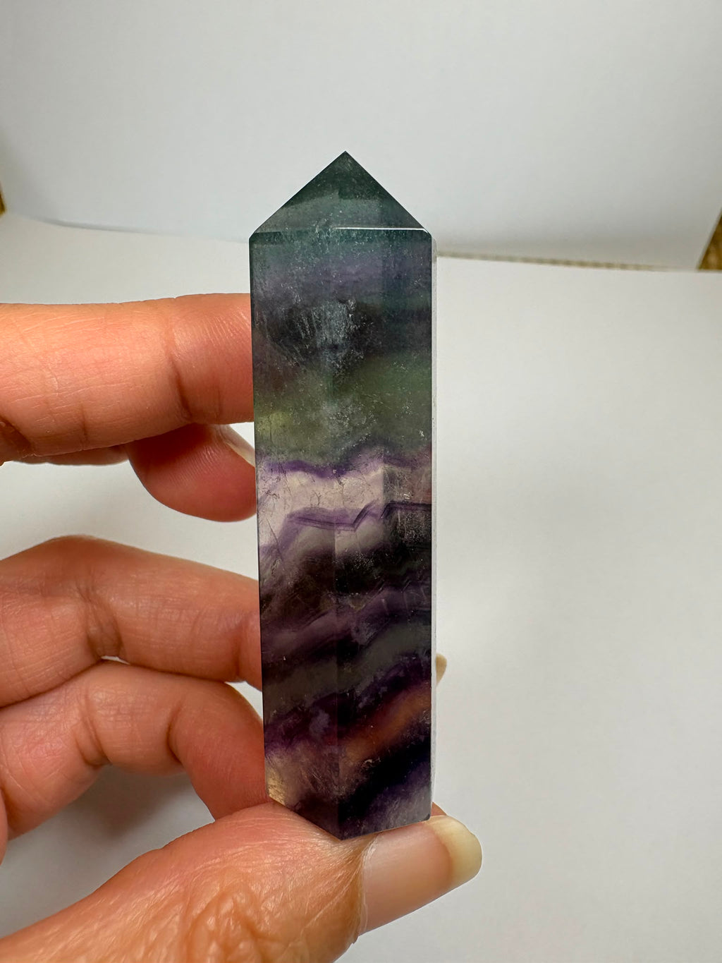 Punta de fluorita arcoíris natural pulida de 6 × 1,5 cm. Pieza única con hermosas bandas de color, ideal para colección, decoración o meditación