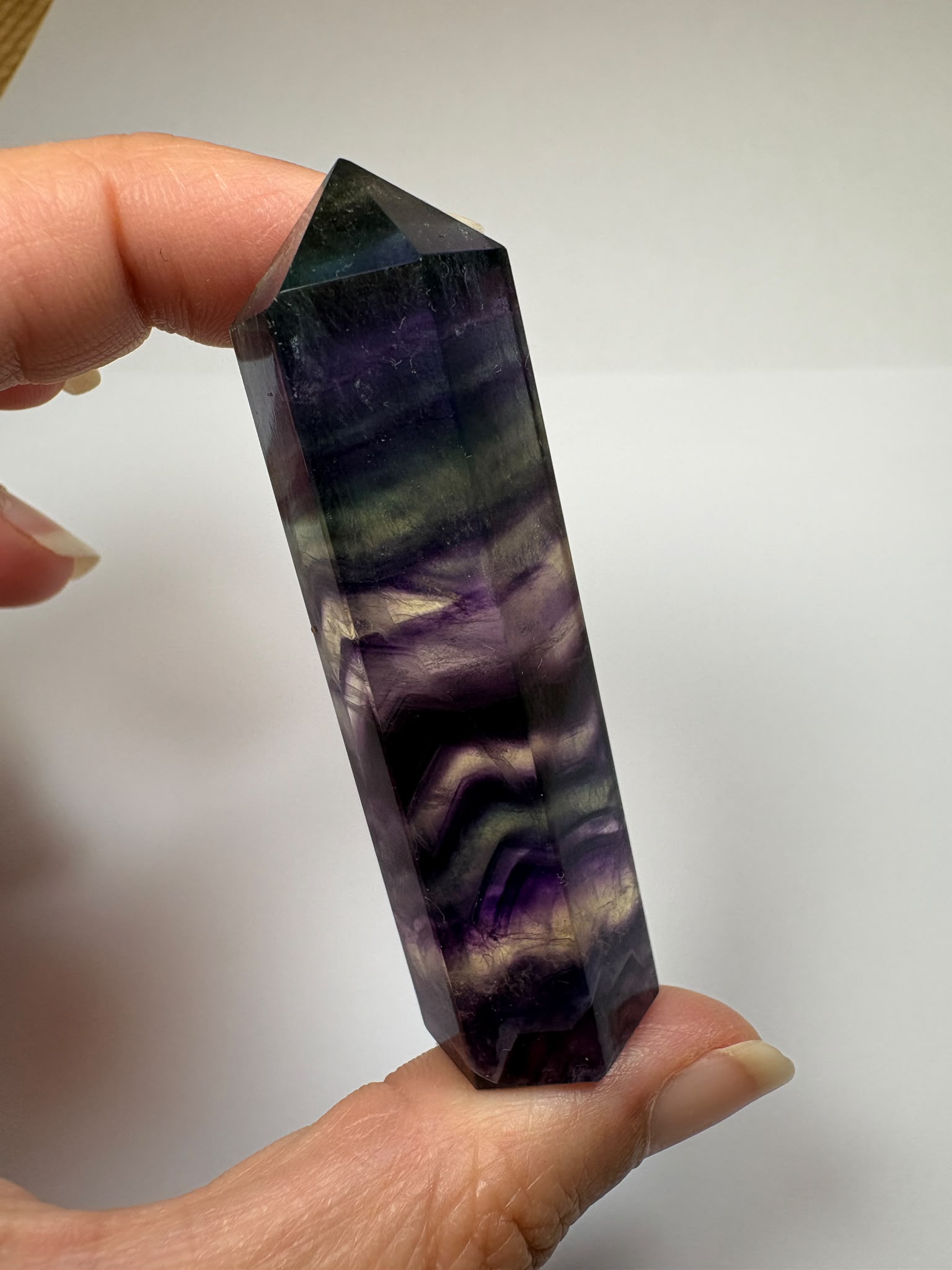 Punta de fluorita arcoíris natural pulida de 6 × 1,5 cm. Pieza única con hermosas bandas de color, ideal para colección, decoración o meditación