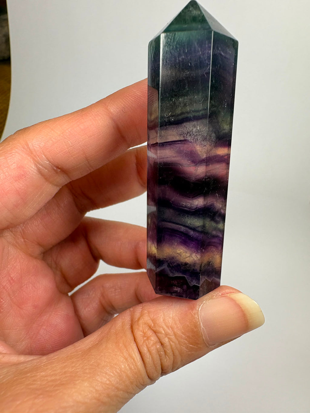 Punta de fluorita arcoíris natural pulida de 6 × 1,5 cm. Pieza única con hermosas bandas de color, ideal para colección, decoración o meditación
