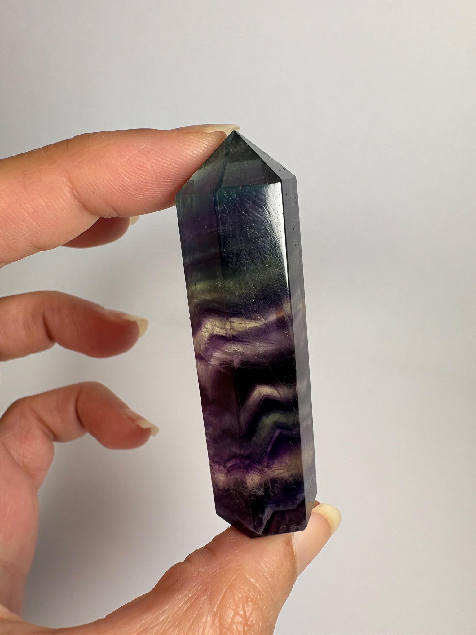 Punta de fluorita arcoíris natural pulida de 6 × 1,5 cm. Pieza única con hermosas bandas de color, ideal para colección, decoración o meditación