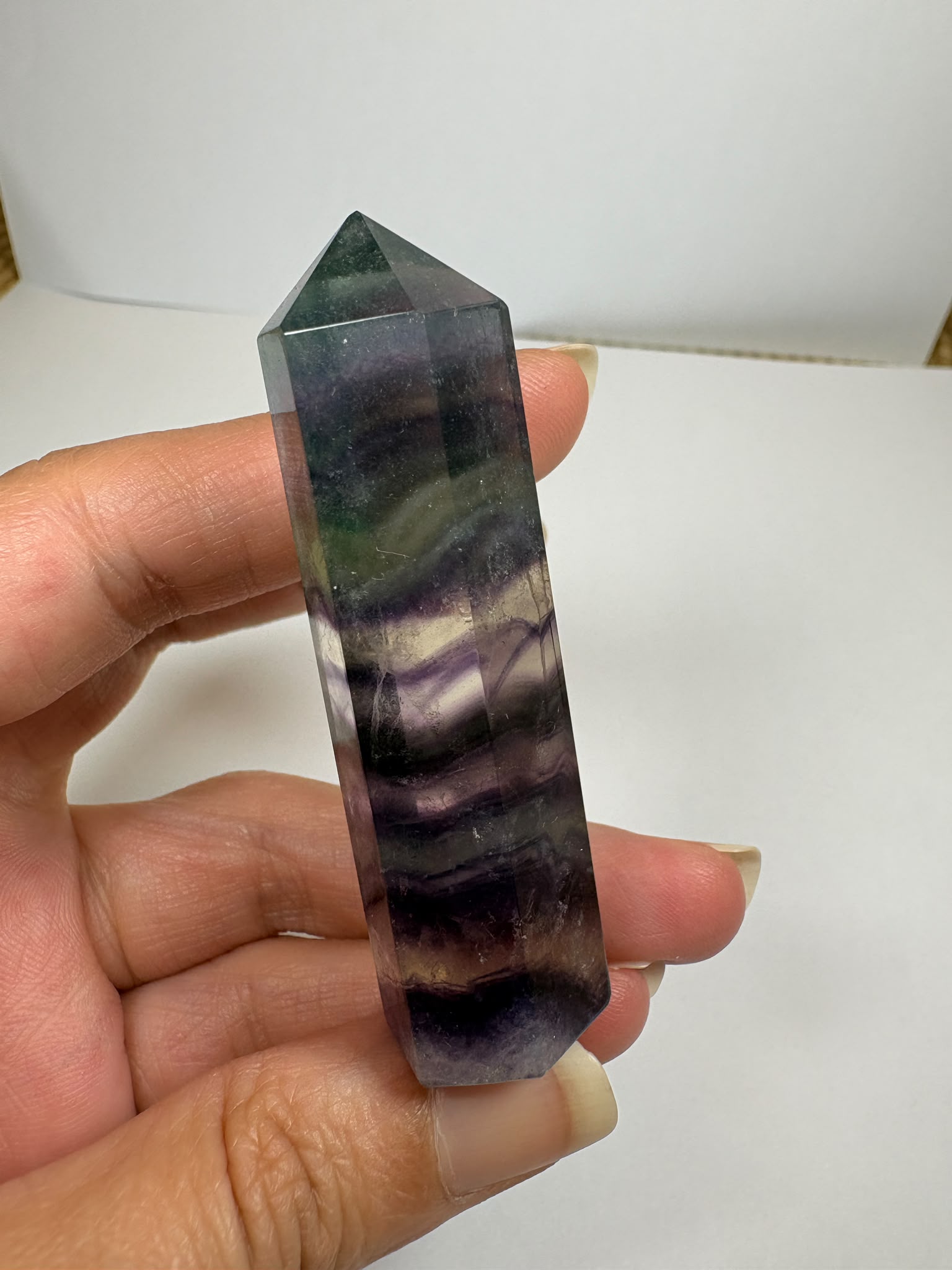 Punta de fluorita arcoíris natural pulida de 6 × 1,5 cm. Pieza única con hermosas bandas de color, ideal para colección, decoración o meditación