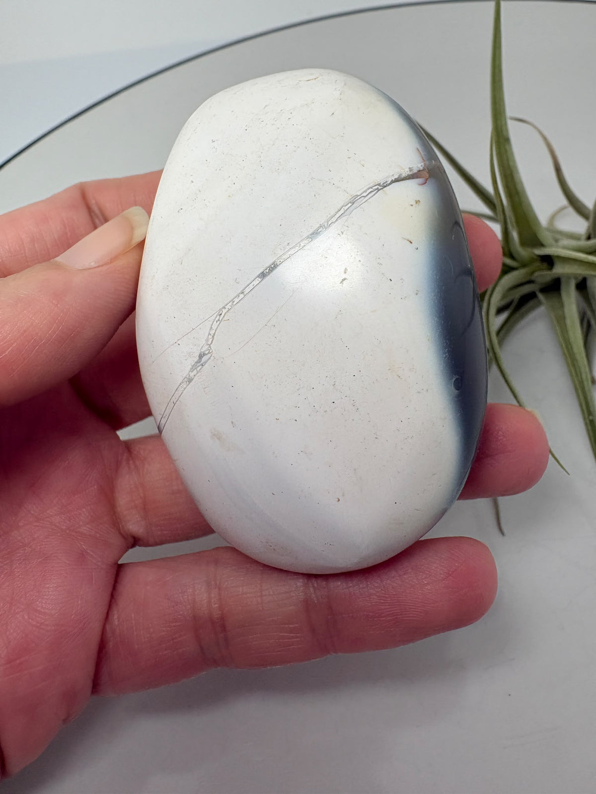 Palmstone de ágata orca en tonos gris azulados y blanco, con acabado pulido. Una pieza única para tu colección o tus momentos de meditación