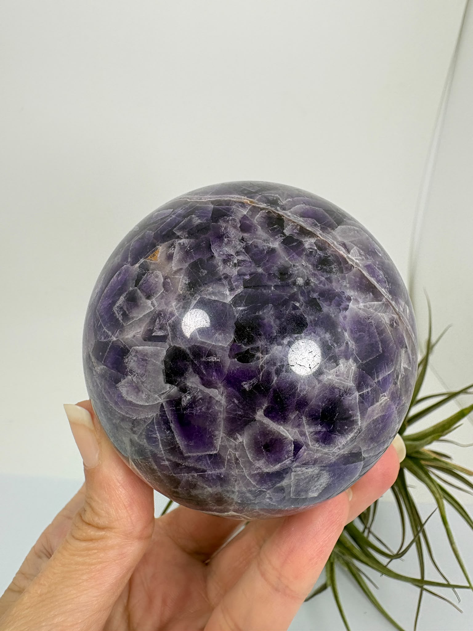 Esfera de amatista africana natural de 6,9 cm. Pieza única de intensos tonos violetas, ideal para colección, decoración, meditación y armonización de espacios. La base no está incluida.