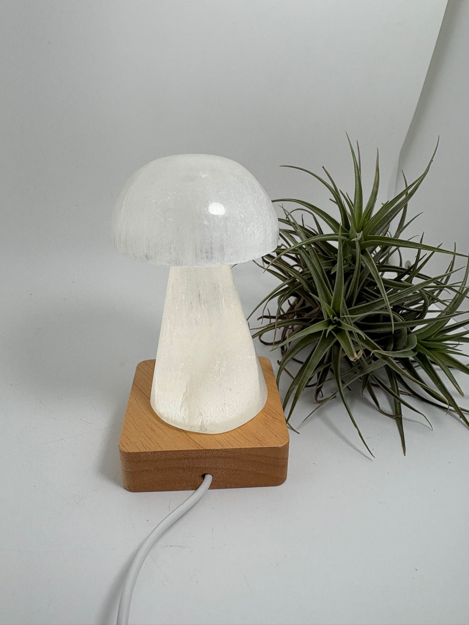 Lámpara usb de selenita natural con base led de madera. Pieza de gran calidad, elegante y luminosa, ideal para decorar y armonizar cualquier espacio.