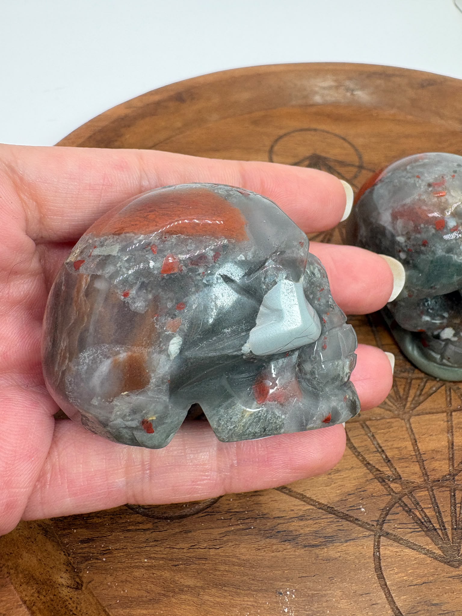 Calavera de jaspe heliotropo natural pulida. Mineral con tonos verdes e inclusiones rojizas. Ideal para colección, decoración o regalo especial.