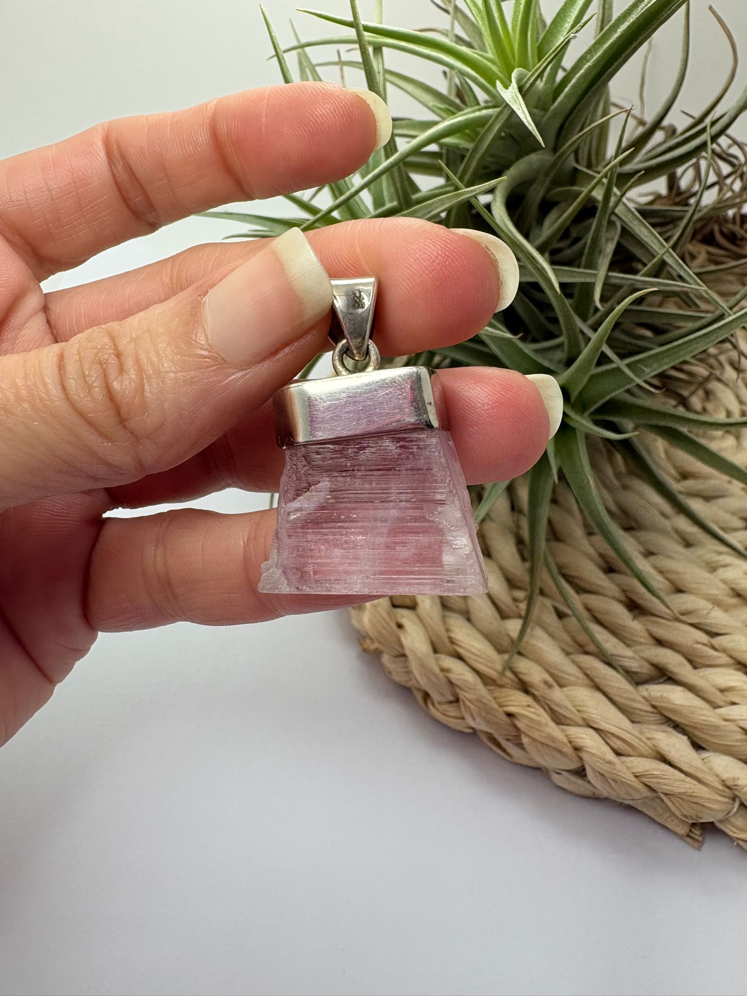 Colgante de kunzita natural en bruto en plata de ley. Piedra rosa asociada al amor, la calma y el equilibrio emocional. Joya con significado.
