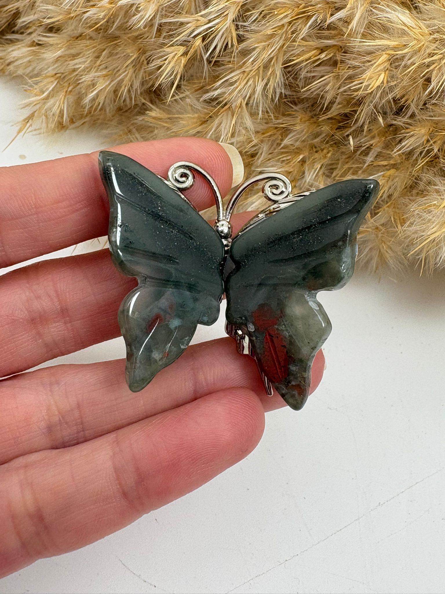 Mariposa de heliotropo pulido, piedra natural con vetas rojizas características. Figura única perfecta para decoración o colección.