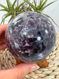 Esfera de mica lepidolita natural en tonos lilas, asociada con la calma, el equilibrio emocional y la relajación. Pieza única con acabado pulido.