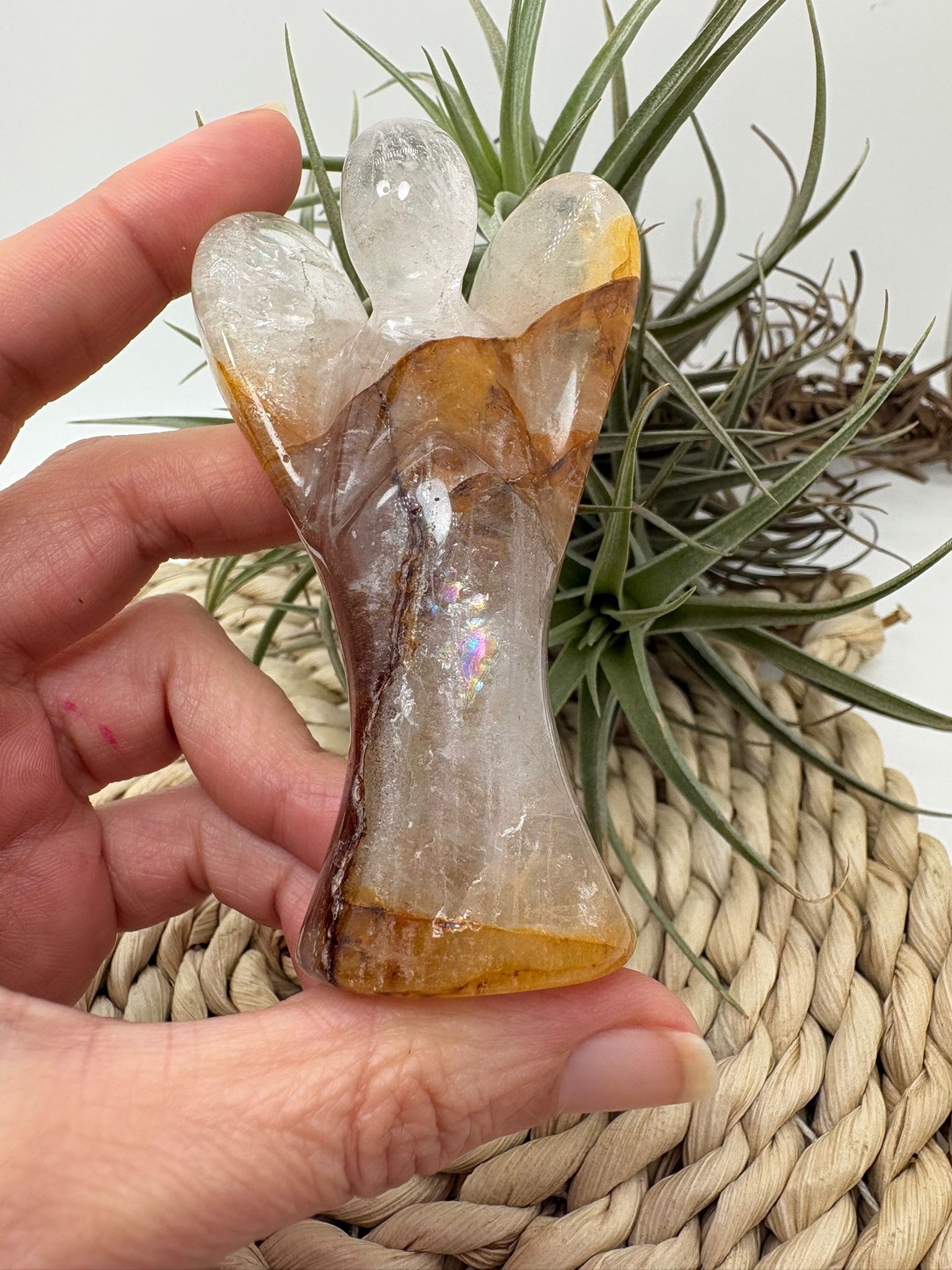 Ángel de cuarzo fuego con inclusiones naturales y arcoíris interior. Pieza única ideal para protección, equilibrio y energía positiva.