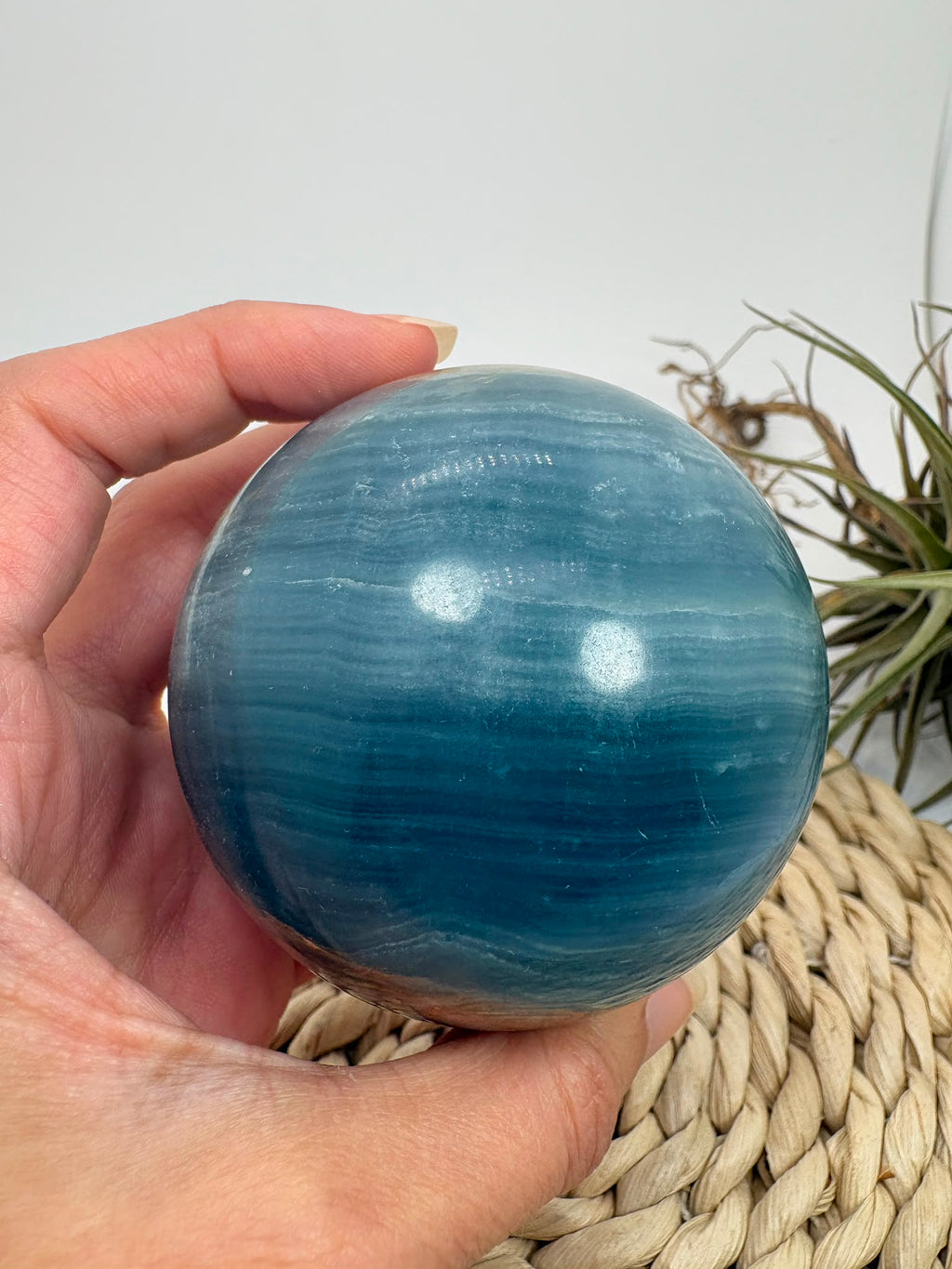 Esfera de ónix azul natural con preciosas bandas y tonalidades azules. Pieza única de acabado pulido, asociada con la calma y la serenidad.