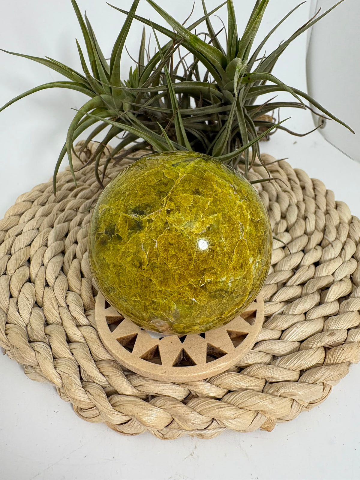 Preciosa esfera de ópalo verde procedente de Madagascar, caracterizada por sus tonalidades verdes, amarillentas y blancas, que forman dibujos naturales únicos en toda la superficie. Su pulido realza el color, el brillo y la riqueza de sus matices.
