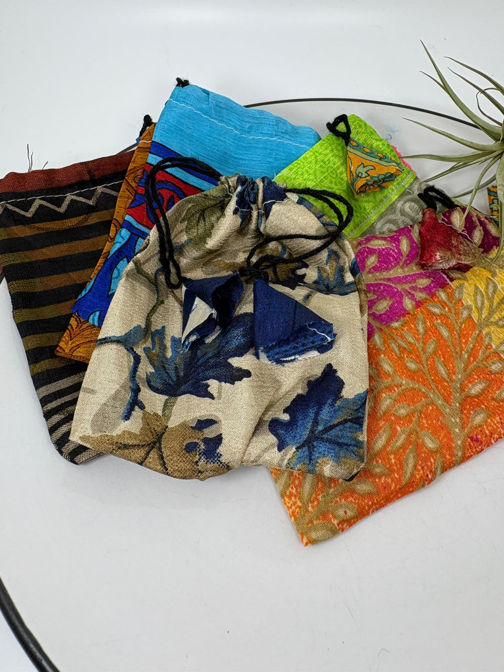 Pack de 6 bolsitas de tela para guardar minerales y joyería. Colores y estampados variados, cierre de cordón y tamaño aproximado de 12 × 10 cm. 