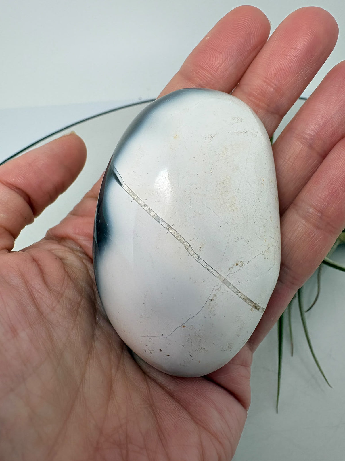 Palmstone de ágata orca en tonos gris azulados y blanco, con acabado pulido. Una pieza única para tu colección o tus momentos de meditación