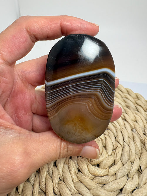 Ágata de Botswana pulida con preciosas bandas marrones, grises y blancas. Una pieza única para meditar, regalar o decorar tu espacio.