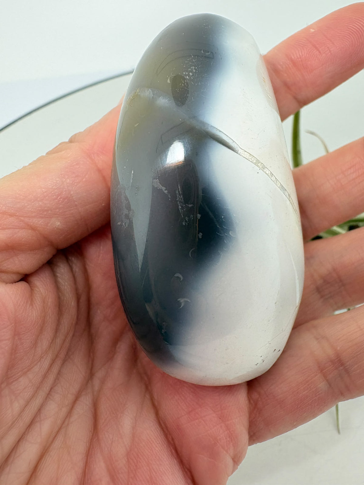 Palmstone de ágata orca en tonos gris azulados y blanco, con acabado pulido. Una pieza única para tu colección o tus momentos de meditación