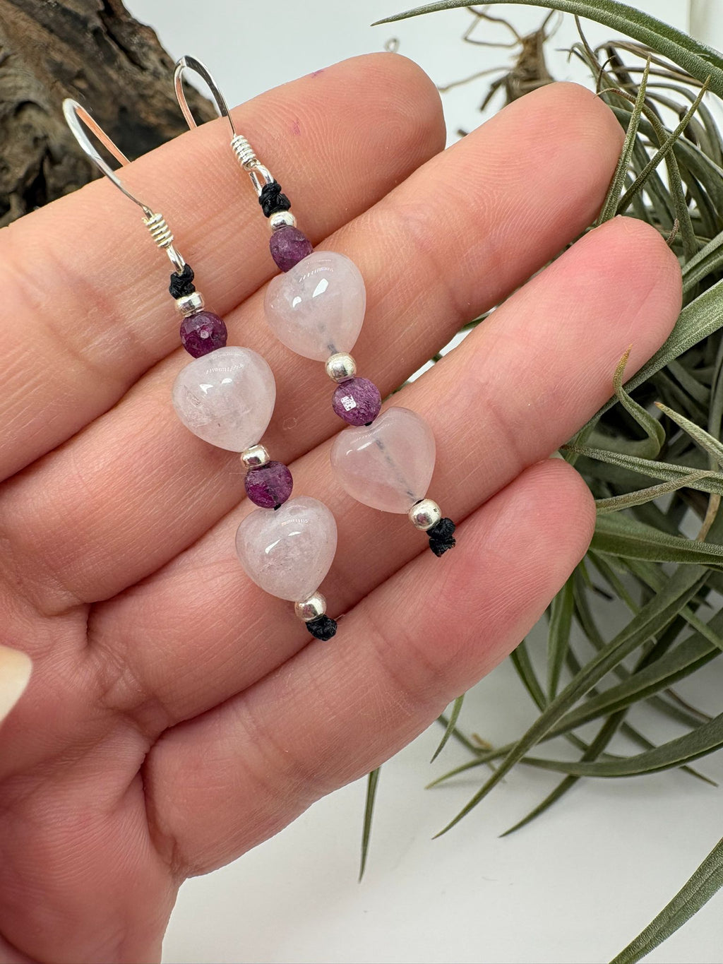 Pendientes artesanales de macramé con corazones de cuarzo rosa y rubí natural. Elaborados con plata de ley 925 e hilo de algodón encerado. Diseño romántico y hecho a mano.