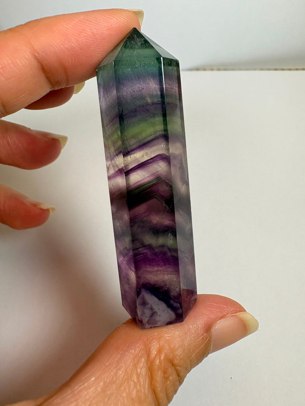 Punta de fluorita arcoíris natural pulida de 6 × 1,5 cm. Pieza única con hermosas bandas de color, ideal para colección, decoración o meditación