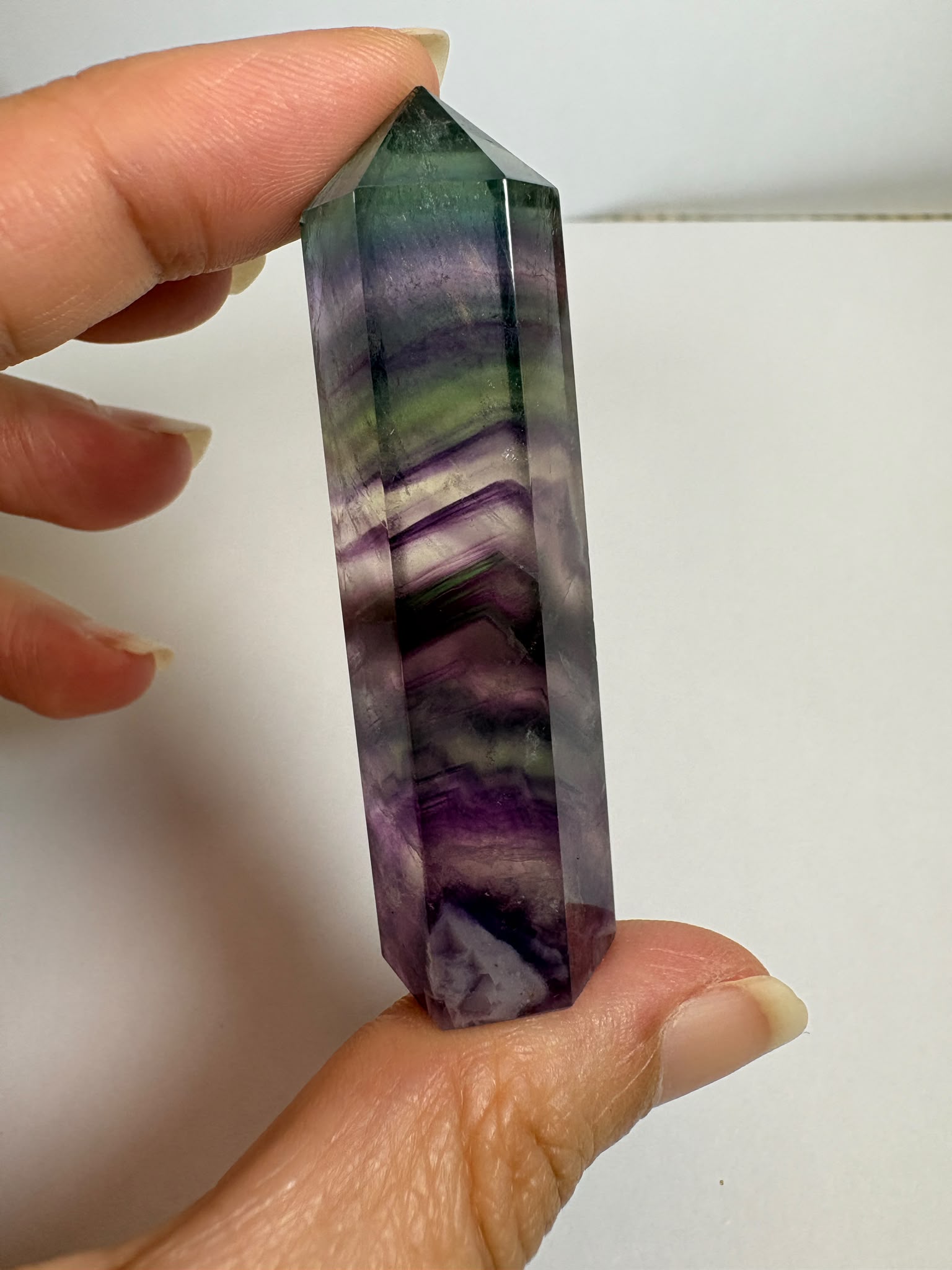 Punta de fluorita arcoíris natural pulida de 6 × 1,5 cm. Pieza única con hermosas bandas de color, ideal para colección, decoración o meditación