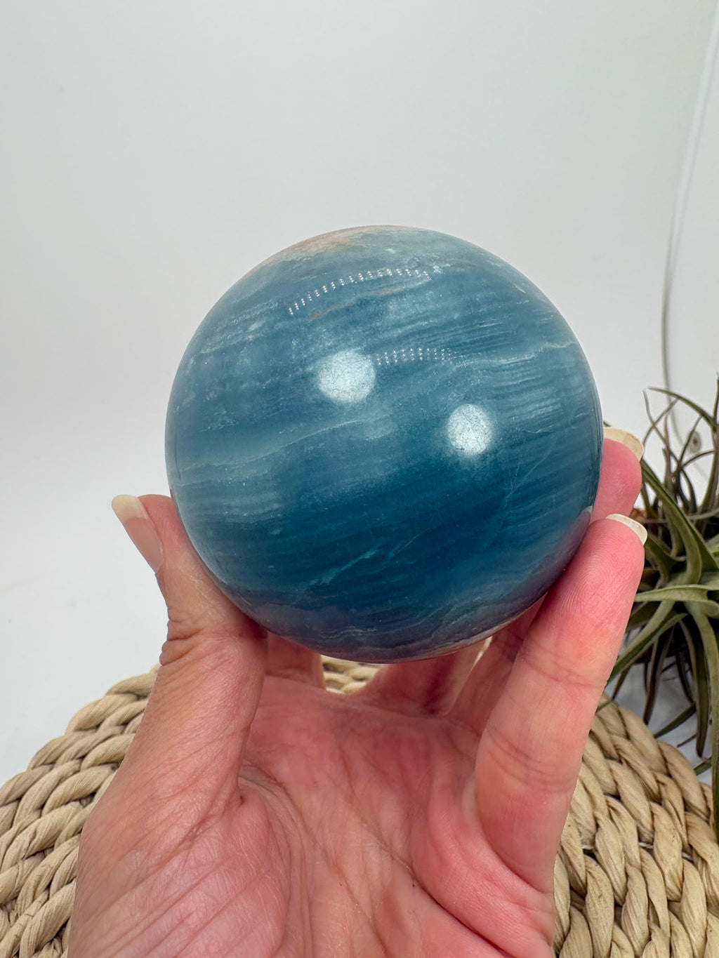Esfera de ónix azul natural con preciosas bandas y tonalidades azules. Pieza única de acabado pulido, asociada con la calma y la serenidad.