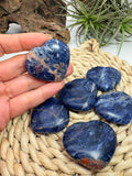 Corazón plano de sodalita natural pulida de aproximadamente 3,5 x 4 cm. Piedra asociada a la intuición, la calma y la comunicación. Pieza única seleccionada intuitivamente.
