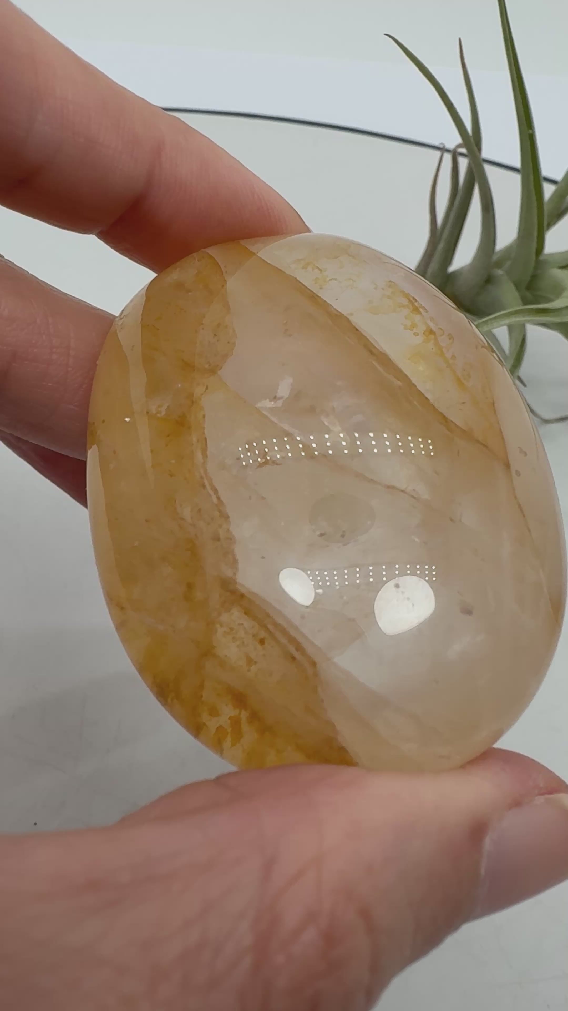 Palmstone de cuarzo hematoide de gran calidad y transparencia. Su interior presenta preciosas inclusiones en tonos anaranjados, rojizos y dorados, acompañadas de dibujos oscuros que forman un paisaje único dentro del cuarzo.